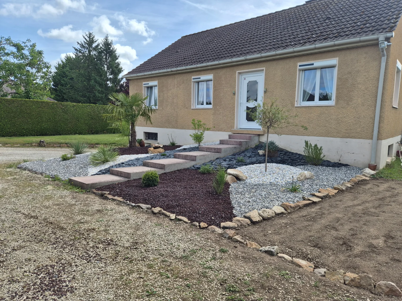 Massif minéral et plantations devant une maison